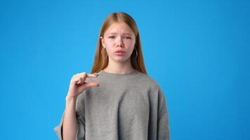Young girl communicates using sign language in front of a bright blue background during a tutorial session video