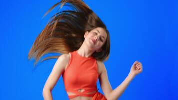 Dynamic dance performance featuring energetic movements against a vibrant blue backdrop video