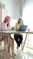 Digital Literacy and Intergenerational Learning. A daughter patiently teaches her elderly mother how to use a laptop, bridging the technology gap at home. video