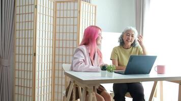 Digital Literacy and Intergenerational Learning. A daughter patiently teaches her elderly mother how to use a laptop, bridging the technology gap at home. video