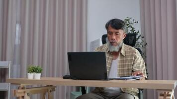 Retired grandfather relaxing with laptop, journaling his daily routine. video