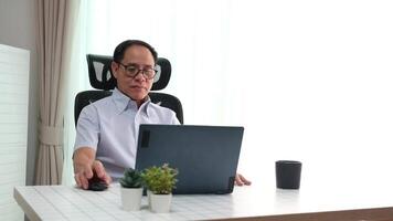 Elderly father using laptop to update news while relaxing in retirement at home. video
