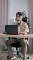 Retired grandfather relaxing with laptop, journaling his daily routine. video