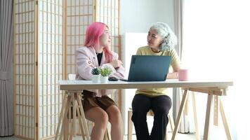 Digital Literacy and Intergenerational Learning. A daughter patiently teaches her elderly mother how to use a laptop, bridging the technology gap at home. video