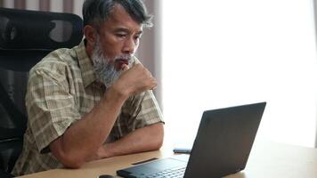 Retired grandfather relaxing with laptop, journaling his daily routine. video