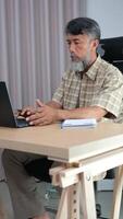 Retired grandfather relaxing with laptop, journaling his daily routine. video