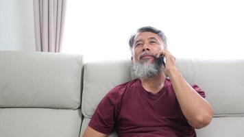 Elderly man in later years journaling, calling a friend, and relaxing at home. video
