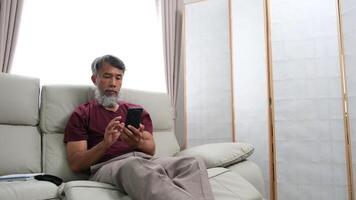 Elderly man in later years journaling, calling a friend, and relaxing at home. video
