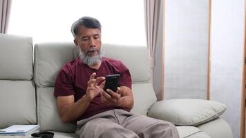 Elderly man in later years journaling, calling a friend, and relaxing at home. video