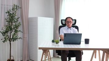 Elderly father using laptop to update news while relaxing in retirement at home. video