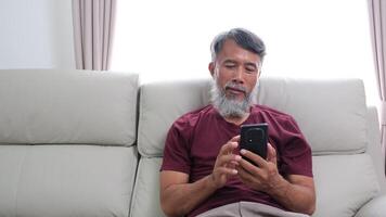 Elderly man in later years journaling, calling a friend, and relaxing at home. video