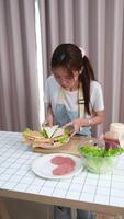 Teenage girl preparing a homemade sandwich at the dining table at home. video