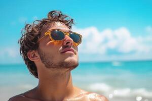 A man wearing sunglasses on the beach photo