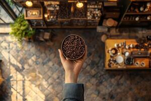 A hand holds a bowl of roasted coffee beans photo
