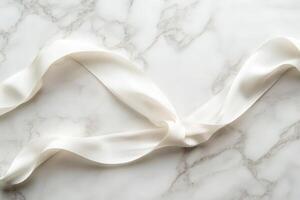 Elegant white satin ribbon on marble background photo