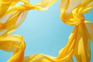 Yellow fabric flowing in the wind against a blue sky photo