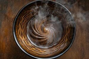 Swirling Liquid in Dark Brown Bowl with Steam photo