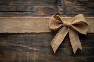 Rustic Burlap Bow on Weathered Wooden Background photo