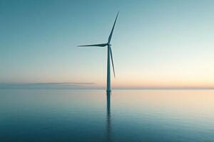A wind turbine is standing on the ocean at sunset photo