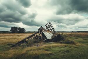 An old wooden shed sits in a field photo