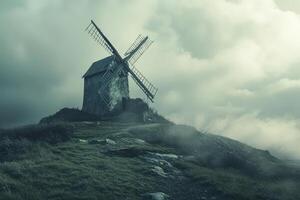A windmill on a hill in the fog photo
