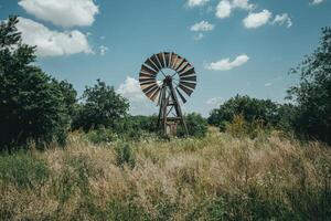 An old windmill in the middle of a field photo