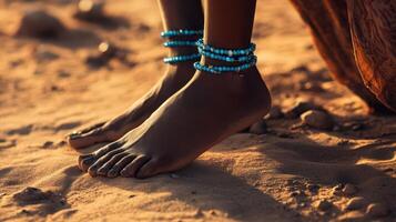 African woman barefoot in the desert with blue beads photo