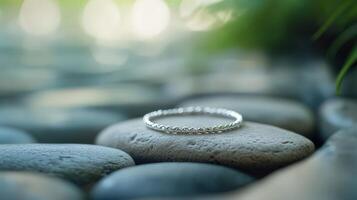 A ring sits on top of a rock in a garden photo