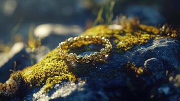 A gold ring sitting on top of a rock photo