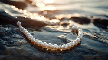 A pearl necklace laying on the rocks photo
