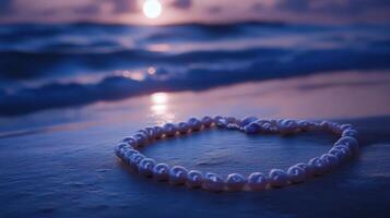 A necklace with pearls on the beach at sunset photo