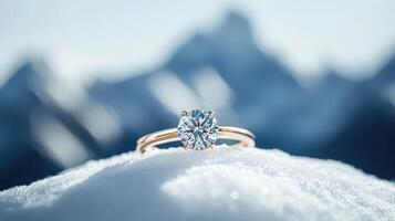 A diamond engagement ring sitting on top of snow photo