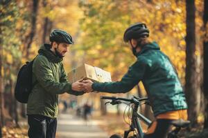 Delivery man gives package to cyclist in autumn park photo