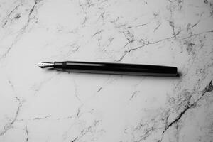 Black Fountain Pen Rests on White Marble Surface photo