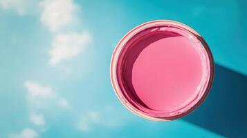 Pink paint in a container against a blue sky photo