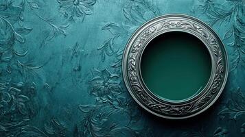 Ornate silver dish holds dark teal paint on textured background photo