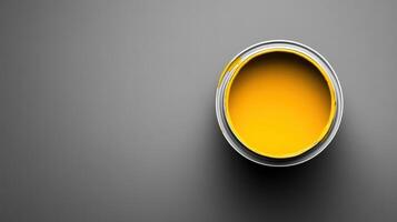 A Can of Bright Yellow Paint on Gray Background photo