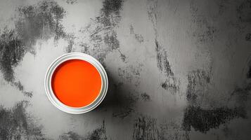 Orange Paint in a White Can on Gray Surface photo