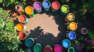 Colorful paint cans arranged in a circle among greenery photo