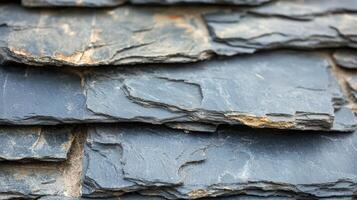Overlapping layers of dark grey slate roofing tiles photo
