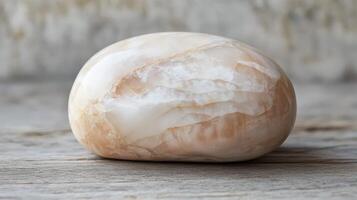 Polished Onyx Stone Resting On Wooden Surface photo