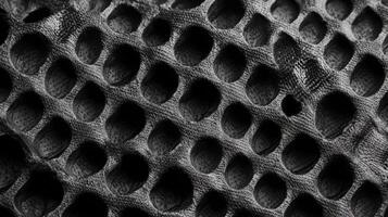 Dark textured surface with circular indentations photo