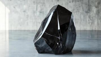 Black Polished Stone Sculpture on Grey Floor photo