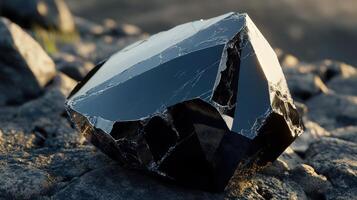 Black Crystal Fragment Resting On Rocks photo