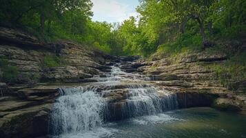Serene Waterfall Cascading Through Rocky Green Forest photo