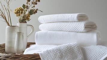 Stacked White Waffle Towels Beside Dried Flowers photo