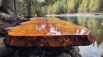 Polished wood slab rests by serene mountain lake photo