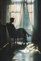 Person sitting in a chair by the window reflecting on emotions photo
