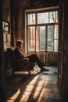 Person reflecting in a sunlit room with large windows photo