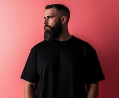 Man with beard poses against a pink background during a photoshoot photo
